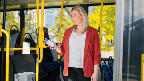 Lachende vrouw checkt uit met haar bankpas op haar mobiele telefoon Lachende vrouw checkt uit met haar bankpas op haar mobiele telefoon