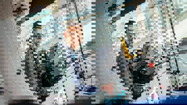 Chauffeur achter het stuur van een bus Chauffeur achter het stuur van een bus